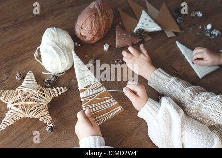 Kind macht Weihnachtsdekoration aus Garn. Stockfoto