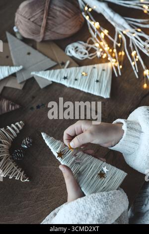 Kind macht Weihnachtsdekoration aus Garn. Stockfoto