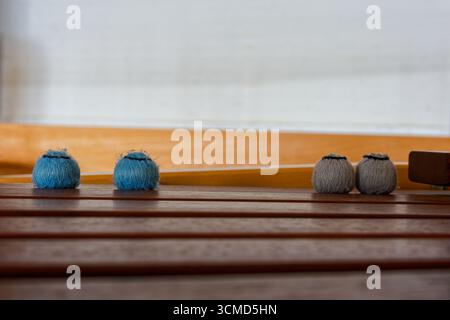 Auf demselben Tisch liegen zwei graublaue Knäuel mit schwarzer Krawatte an der Krone und in der Nähe zwei weiße Knäuel. Die ausgewogenen Farben deuten auf einen Plan für strukturierte p Stockfoto