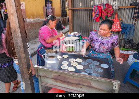 Chichicastenango, Guatemala - 3. Juli 2025: Frauen machen Tortillas auf dem Santo Tomas Markt in Chichicastenango, Guatemala. Stockfoto