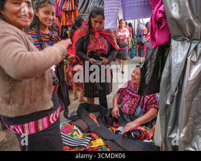 Chichicastenango, Guatemala - 3. Juli 2025: Frauen kaufen traditionelle Kleidung auf dem Santo Tomas Markt in Chichicastenango, Guatemala. Stockfoto