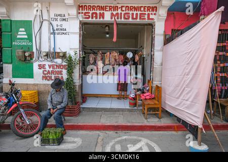Chichicastenango, Guatemala - 3. Juli 2025: Frauen kaufen in einer Metzgerei in Chichicastenango, Guatemala. Stockfoto
