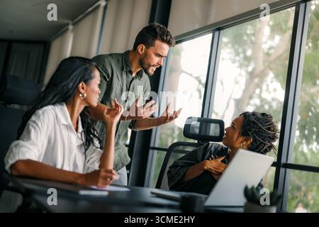 Geschäftskollegen, die während eines Meetings in einem modernen Büro ein Missverständnis haben und streiten Stockfoto