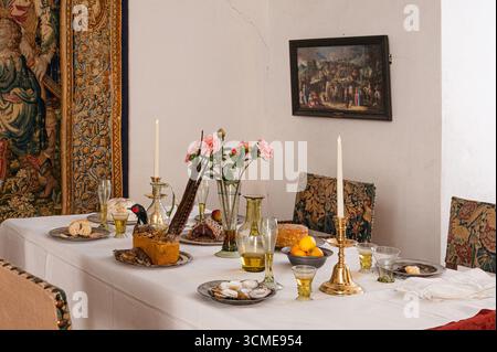 Elegante Tischdekoration im Stil des 16. Jahrhunderts mit historischen Details, Blumen und rustikalem Charme – eine Reise zurück in die Renaissance. Dänemark, August 202 Stockfoto