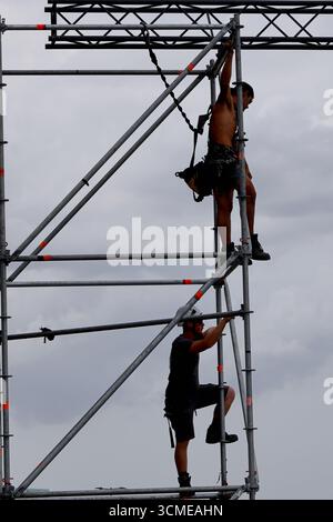 Arbeiter in gut sichtbarer Kleidung demontieren nach Sail 2025 in Amsterdam, Niederlande, temporäre Eventstrukturen, wobei die Besatzung die Verkleidungen abbaut. Stockfoto
