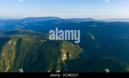 Panoramablick der Drohne auf den Miljacka Canyon mit dramatischen Klippen, Wäldern und umliegenden Bergen im Abendlicht Stockfoto