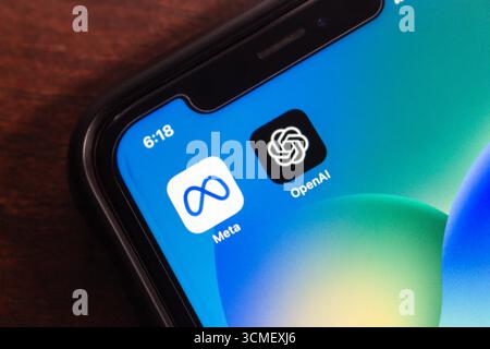 Nahaufnahme eines Smartphones, das Meta- und OpenAI-App-Symbole nebeneinander zeigt und wichtige Akteure in KI- und Technologieinnovation repräsentiert. Stockfoto