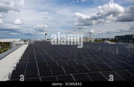 München, Deutschland. September 2025. Solarpaneele werden in einer Parkgarage am Flughafen München installiert. Sie produzieren den Strom für den bisher größten öffentlichen Ladeplatz für E-Autos in Bayern, der sich im selben Parkhaus befindet. Der neue Ladestation am Flughafen wird 275 Ladestationen haben. Quelle: Leonie Asendorpf/dpa/Alamy Live News Stockfoto