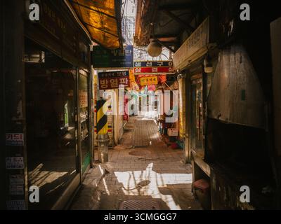 Alte heruntergekommene, schroffe Gasse in Seoul Korea mit Schildern in der Nähe des Sewoon Plaza mit Geschäften, die alte elektronische Teile verkaufen Stockfoto