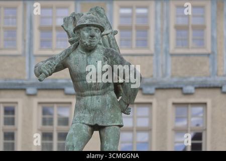 Holzträger von Bernhard Frydag, 1914, männliche Figur mit Korb mit Holz auf dem Rücken, Symbol für Forstwirtschaft, Holzfäller, Holz, Brunnen, wo Stockfoto