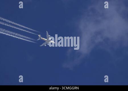 Flugzeuge am Himmel in Reiseflughöhe. Airbus A380 der Fluggesellschaft Ethihad auf dem Weg nach Abu Dhabi. Kondensstreifen am Himmel. Diese künstlichen Wolken sind es Stockfoto