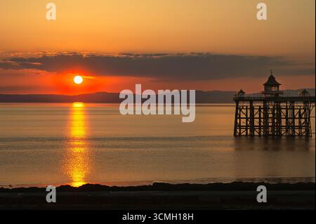 Sonnenuntergang über dem Meer, ein goldenes Leuchten auf dem Clevedon Pier Stockfoto