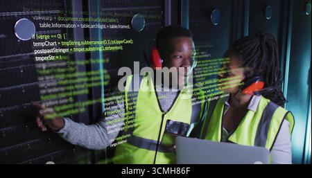 Techniker tragen Sicherheitswesten, die mit einem Laptop im Rechenzentrum auf das Server-Rack zeigen, Code-Overlay Stockfoto