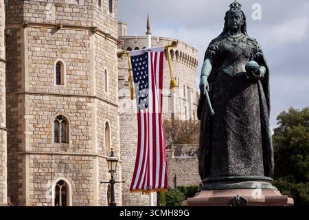 Während Präsident Donald Trump sich auf einen dreitägigen Staatsbesuch nach Großbritannien vorbereitet, hängt das US-Sternenbanner neben der Statue von Königin Victoria vor Windsor Castle, wo er am 16. September 2025 bei Mitgliedern der königlichen Familie in London, England, übernachten wird. Stockfoto