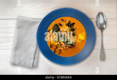 Tisch fertig mit Bouillabaisse-Suppe. Blick von oben auf köstliche Fischsuppe mit Fischfilet Muscheln, anderen Schalentieren und Gemüse. Stockfoto