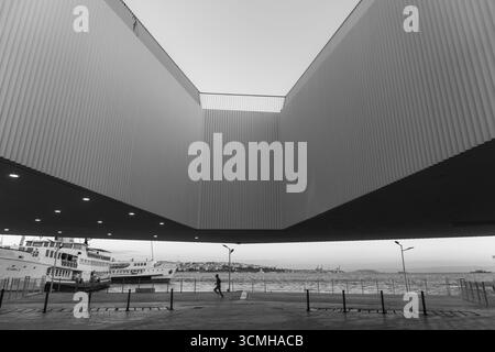 Ein auffälliges Schwarz-weiß-Foto zeigt die moderne Architektur eines Fährterminals in Istanbul. Die geometrischen Linien des Gebäudes bilden den Rahmen für die Belegung Stockfoto