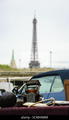 Flohmarkt in Paris (Frankreich). Oldtimer-Modell und anderes Zeug auf einem Stand mit Blick auf die seine-Ufer und den Eiffelturm. Stockfoto