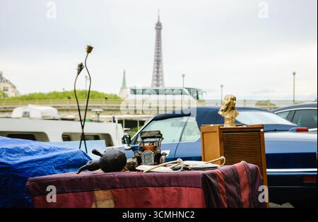 Flohmarkt in Paris, Frankreich. Oldtimer-Modell und anderes Zeug auf einem Stand mit Blick auf die seine-Ufer und den Eiffelturm. Stockfoto