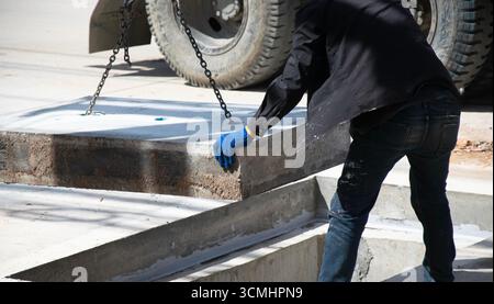 Die Arbeiter installieren eine große Betonabdeckung. Stockfoto