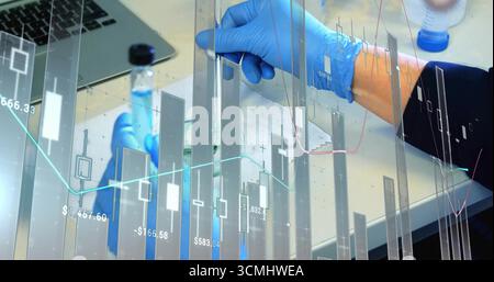 Hände mit Nitrilhandschuhen zum Pipettieren von Flüssigkeit in einen graduierten Zylinder an der Laborstation mit finanzieller Überlagerung Stockfoto