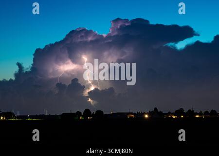 Dramatisches Gewitter mit blinkenden Blitzen, die einen dunklen Nachthimmel erleuchten Stockfoto