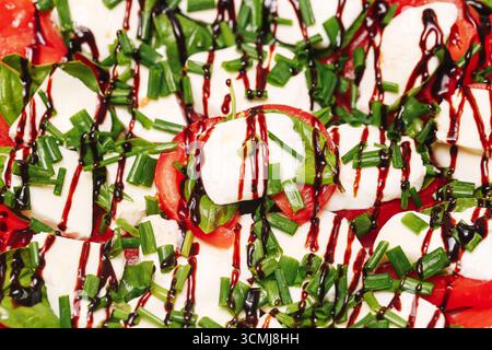 Caprese-Salat mit Mozzarella-Tomate und Sauce. Frisches vegetarisches Essen mit Kräutern. Gesunde Bio-Diät Mahlzeit Nahaufnahme. Stockfoto