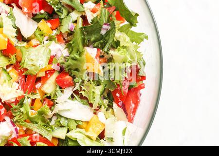 Frischer Gemüsesalat in einer Schüssel. Bunte gesunde Lebensmittel-Mischung mit Salat Tomaten Pfeffer Gurke. Natürliche Bio-Mahlzeit voller Vitamine. Stockfoto