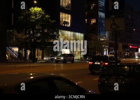 Warschauer Stadtverkehr bei Nacht mit neonbeleuchteten Schildern und Bewegungsunschärfen Stockfoto