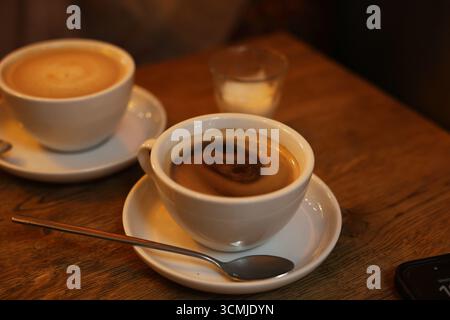 Latte- und Espresso-Tassen – Warschauer Café-Drinks, Holztisch, sozialer Lebensstil, Kaffeekultur Polen Stockfoto