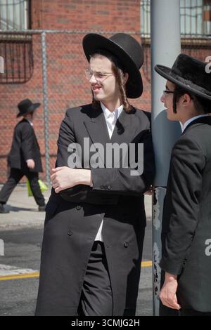 Eine religiöse jüdische Straßenszene in New York City mit drei orthodoxen Jungen. Eine urbane Landschaft in New York City. Stockfoto