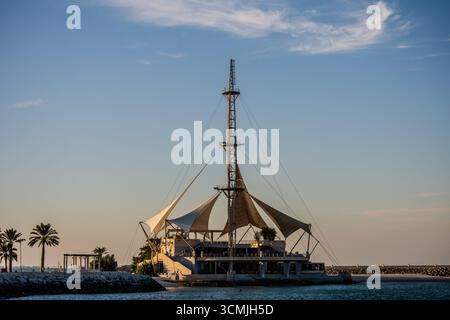 Der Freizeitkomplex Marina Waves mit seinem markanten segelförmigen Baldachin befindet sich entlang der Uferpromenade in Kuwait City, Kuwait. Kuwait City, Kuwait. Stockfoto