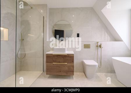 Modernes Bad mit eleganten Armaturen und natürlichen Materialien in stilvoller, geräumiger Umgebung Stockfoto