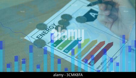 Analyse der Energieeffizienzbewertung auf dem Schreibtisch mit der rechten Hand, mit Münzen und Kartenüberlagerungen Stockfoto
