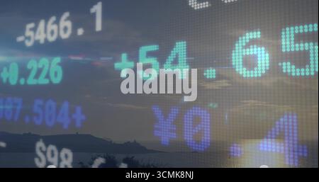 Anzeige gepixelter Finanzdaten über der Silhouette des Hügels in der Abenddämmerung mit Währungssymbolen und gepunktetem Raster Stockfoto