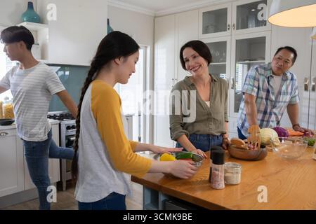 Vielfältige Familienzubereitung von Gemüse auf Kücheninsel mit Stahlschale und Nudelgläsern Stockfoto