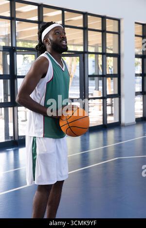 Basketballspieler mit Ball auf blauem Platz mit weißen Linien Stockfoto