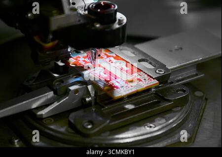 Draht-Bonder-Pressmaschine in Betrieb mit einer Leiterplatte, die geklebt wird Stockfoto