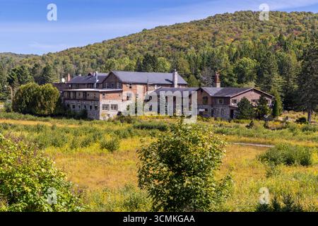 Das verfallene Sanatorium steht inmitten von bewachsener Vegetation und strahlt in der Herbstsaison eine unheimliche Atmosphäre aus, in der Verlassenheit und Verfall herrscht Stockfoto