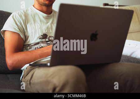 Zagreb, Kroatien - 16. September 2025: Mittelteil eines Reifen Mannes, der zu Hause Laptop benutzt Stockfoto