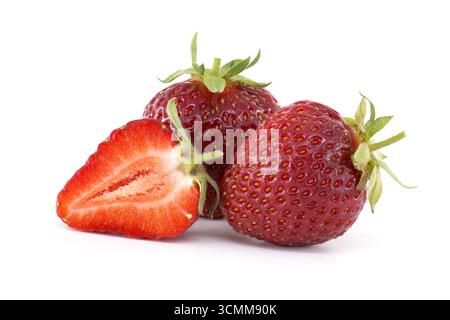 Nahaufnahme reifer Erdbeeren, einige ganze und eine in Scheiben geschnitten, mit leuchtender Farbe und Textur vor weißem Hintergrund. Stockfoto