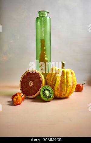 Kreatives Stillleben mit frischem Obst, Gemüse und Glasflaschen. Minimalistische Essenszusammensetzung im rustikalen Stil. Gesunde Ernährung, Bio-Lebensstil und Stockfoto