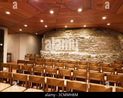 Einsiedeln, Schweiz - 28. September 2022: Kapelle mit Steinmauer und Holzstühlen im Kloster Einsiedeln, Schweiz. Stockfoto