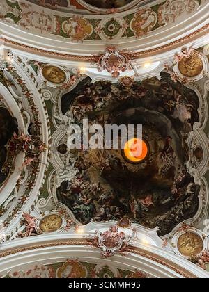 Einsiedeln, Schweiz - 28. September 2022: Kunstvolle Freskomalereien an der Decke einer historischen Kirche im Kloster Einsiedeln, Schweiz. Stockfoto