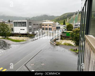 Einsiedeln, Schweiz - 28. September 2022: Städtische Hochwasserszene mit Industriegebiet, kleiner Brücke und Schanze in Einsiedeln, Schweiz Stockfoto