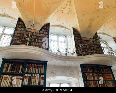 Einsiedeln, Schweiz - 28. September 2022: Luxuriöses Bibliotheksdesign mit umfangreicher Buchsammlung und kunstvoller Dekordecke in Einsiedeln Abbe Stockfoto