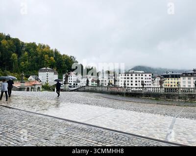 Einsiedeln, Schweiz - 28. September 2022: Schweizer Gebäude und Landschaft an einem nebeligen, regnerischen Tag mit Regenschirmen in Einsiedeln, Schweiz Stockfoto