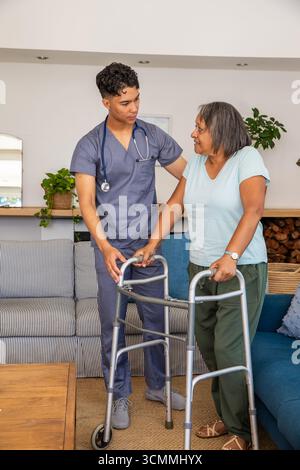 Hispanische Pflegekraft, die afroamerikanische Seniorin mit Walker und Stethoskop unterstützt Stockfoto