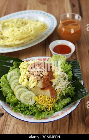 Rujak Juhi Asinan Jakarta. Traditioneller indonesischer Salat mit gelben Nudeln, Gemüse und gegrillten Tintenfisch-Crackern mit Erdnussdressing. Stockfoto