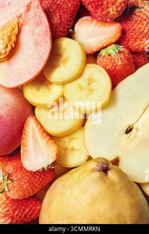 Lebendiges Sortiment an frisch geschnittenen Früchten Pfirsiche, Birnen, Bananen und Erdbeeren, Hintergrund aus Früchten, Nahaufnahme von frischen Erdbeeren, Äpfeln und Birnen Stockfoto