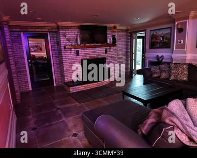 Jenkintown, Pennsylvania, USA - 01. April 2025: Einladendes Wohnzimmer mit separatem Sofa, Kamin, polierten Böden Stockfoto